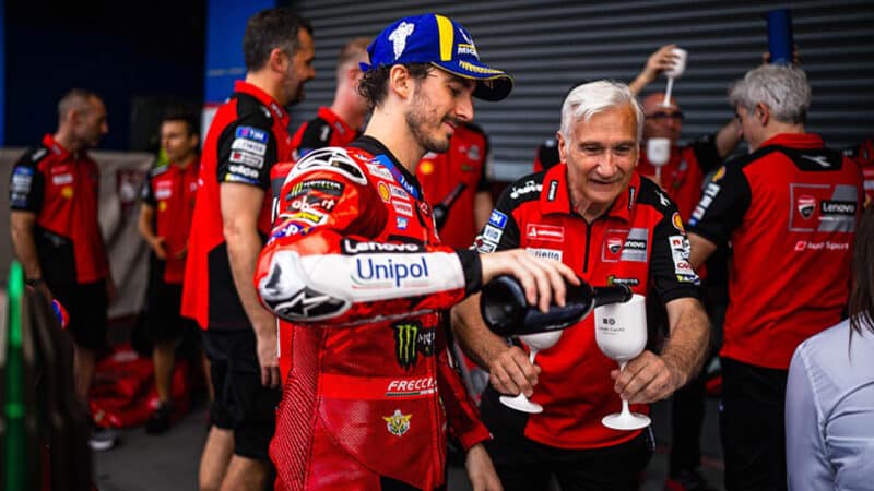 Pecco Bagnaia fills glass of Davide Tardozzi in Ducati pit garage after 2025 MotoGP Thai GP