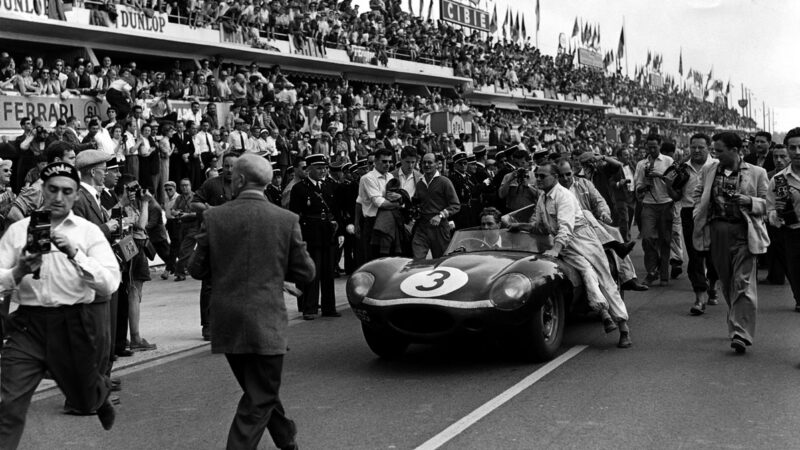 Ron Flockhart steers the winning car through the Le Mans crowds – with Wilkie centre-stage, as usual