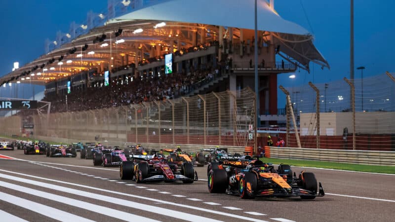 Piastri leads Charles Leclerc’s Ferrari at the start of the Bahrain GP; he’d also take fastest lap and the win
