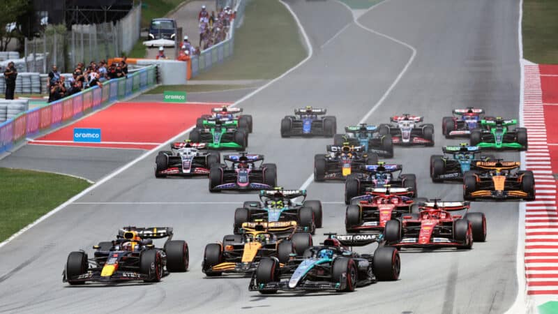 Max Verstappen (Red Bull-Honda), Lando Norris (McLaren-Mercedes) and George Russell (Mercedes) lead the field into the first corner after the start off the 2024 Spanish Grand Prix