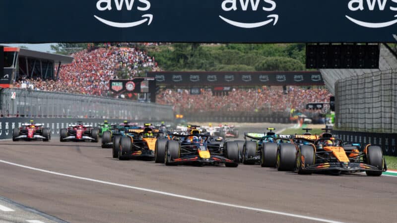 Max Verstappen (Red Bull-Honda) and Oscar Piastri (McLaren-Mercedes) lead the field at the start of the 2025 Emilia Romagna Grand Prix in Imola