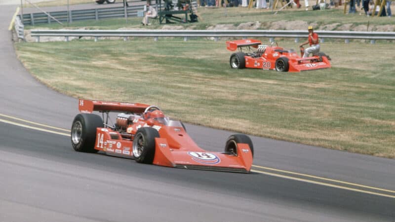 A.J. Foyt (14) in action, passing Gordon Johncock (20) during race at Indianapolis Motor Speedway