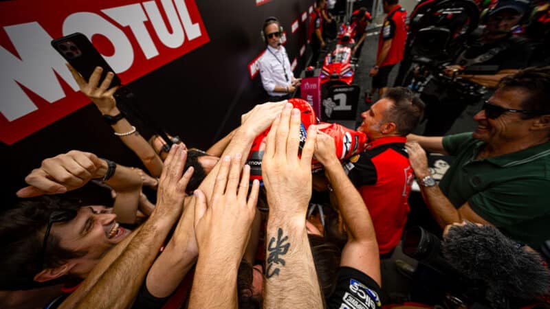 Ducati crew pat the head of Marc Marquez after victory in the 2025 MotoGP Assen TT