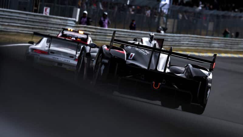 Rear view of Toyota Hypercar and Porsche LMGT3 car on track at Le Mans