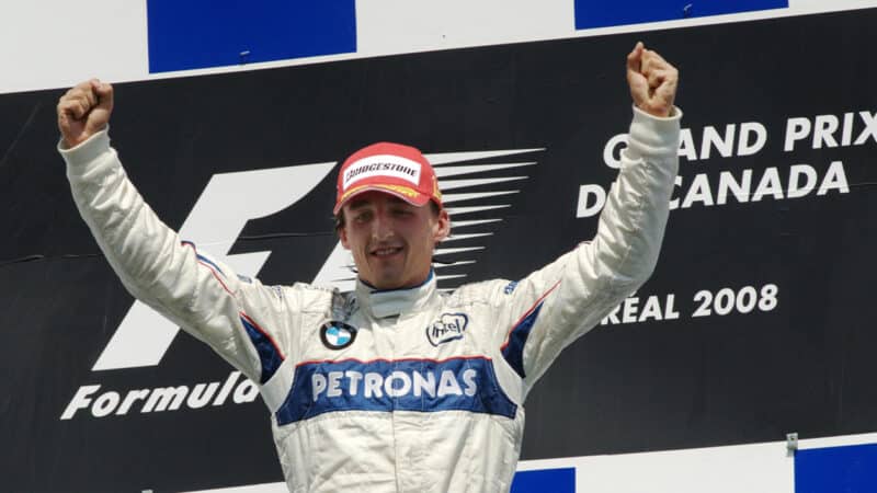 Robert Kubica raises his arms on the podium as he celebrates his maiden F1 win win in the 2008 Canadian Grand Prix