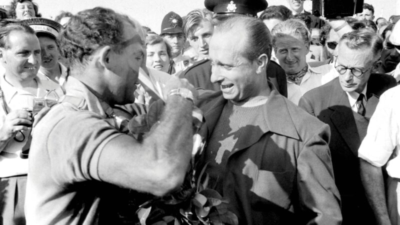 Stirling Moss and Fangio hug
