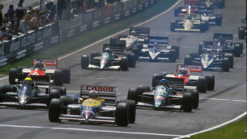 Nigel Mansell (Williams-Honda) leads Gerhard Berger (Toleman-BMW), Ayrton Senna (Lotus-Renault) and the rest of the field at the start of the 1986 British Grand Prix