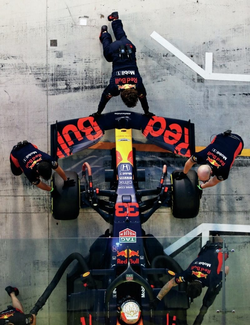 Red Bull of Max Verstappen is pushed into the pit garage