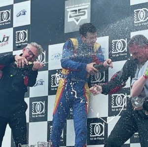 Champagne is sprayed on the podium at the Val de Vienne historic racing meeting